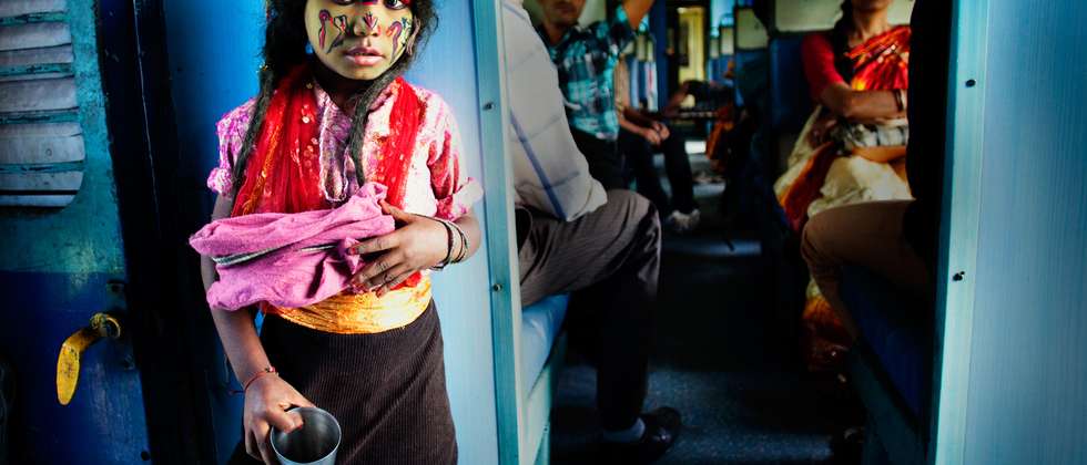 "Poor God", boy disguised as a deity on a local train in India begging for alms