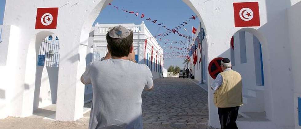 File picture shows an Israeli tourist taking a picture outside the synagogue of La Ghriba on the southern Tunisian island of Djerba on May 25, 2005 ( AFP Photo/Fethi Belaid )