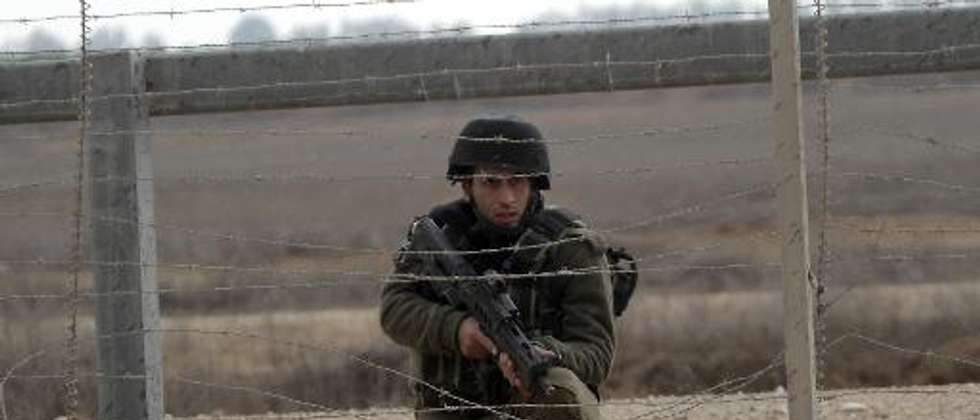 An Israeli soldier keeps watch next to the security fence standing on the Gaza border with Israel, east of Khan Yunis, in the southern Gaza Strip, on November 23, 2012 ( (AFP/File, Said Khatib) )