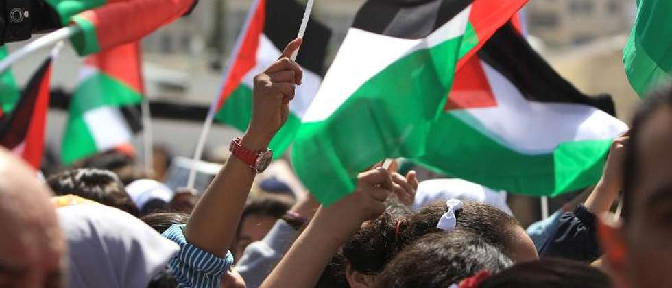 Palestinians wave their national flag on March 20, 2014, in the West Bank city of Ramallah ( Abbas Momani (AFP) )
