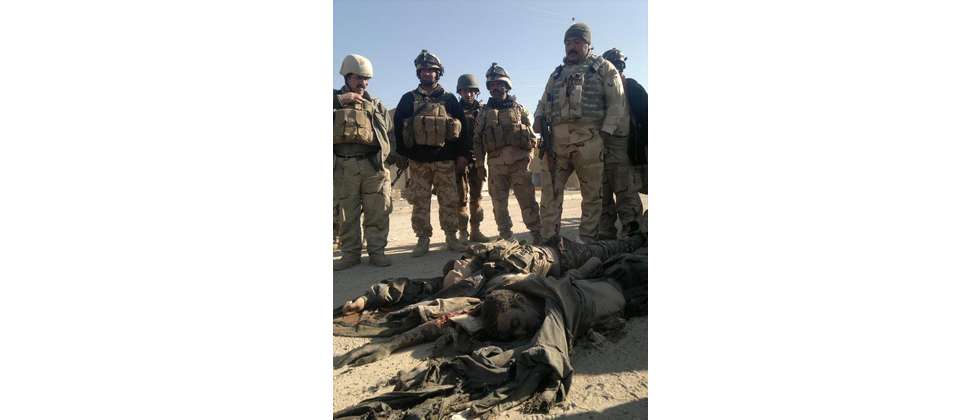 Iraqi soldiers look at bodies of anti-government fighters affiliated killed during a military operation against them on February 9, 2014, in Ramadi, west of Baghdad ( Azhar Shallal (AFP) )