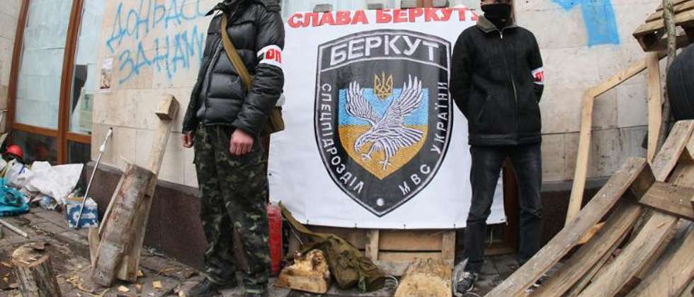 Pro-Russia activists stand in front of a placard bearing the logo of Ukraine's disbanded elite Berkut riot police reading "Glory to Berkut" as they guard a barricade in the eastern Ukrainian city of Donetsk on April 14, 2014 ( Alexander Khudoteply (AFP) )