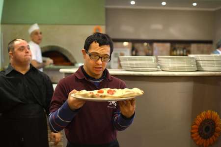 Alessandro Giusto (C), a young man with Down syndrome, serves a pizza at the Girasoli restaurant in Rome on January 28, 2014 ( Gabriel Bouys (AFP/File) ) Alessandro Giusto (C), a young man with Down syndrome, serves a pizza at the Girasoli restaurant in Rome on January 28, 2014 ( Gabriel Bouys (AFP/File) )