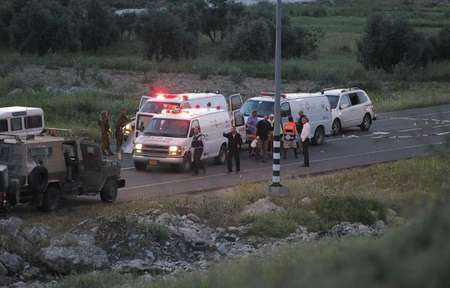 La police israélienne et les secours inspectent les lieux d'une fusillade près d'Hebron le 14 avril 2014 ( Hazem Bader (AFP) )