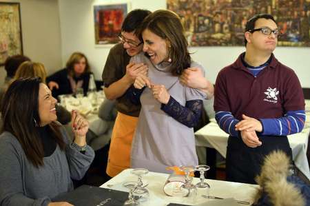 Simone Ippoliti (2nd L), a young waiter with Down syndrome, jokes with customers next to his colleague Alessandro Giusto (R) at the Girasoli restaurant in Rome on January 28, 2014 ( Gabriel Bouys (AFP/File) ) Simone Ippoliti (2nd L), a young waiter with Down syndrome, jokes with customers next to his colleague Alessandro Giusto (R) at the Girasoli restaurant in Rome on January 28, 2014 ( Gabriel Bouys (AFP/File) )